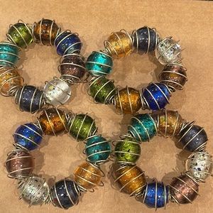 4 napkin Rings colorful glass with copper color metal around.